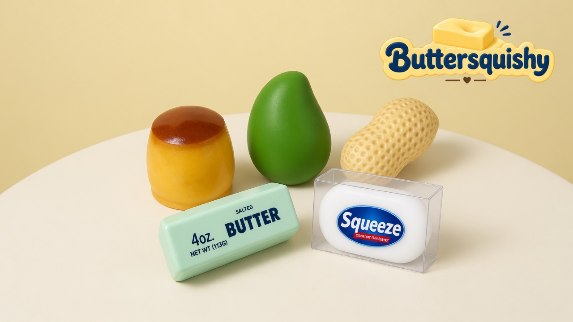 Five Mixed Butter Pack toys — caramel custard cup, green mango egg, ridged peanut, mint salted-butter loaf, and boxed Squeeze soap — on a soft light-yellow cream studio with the Buttersquishy logo in the upper right