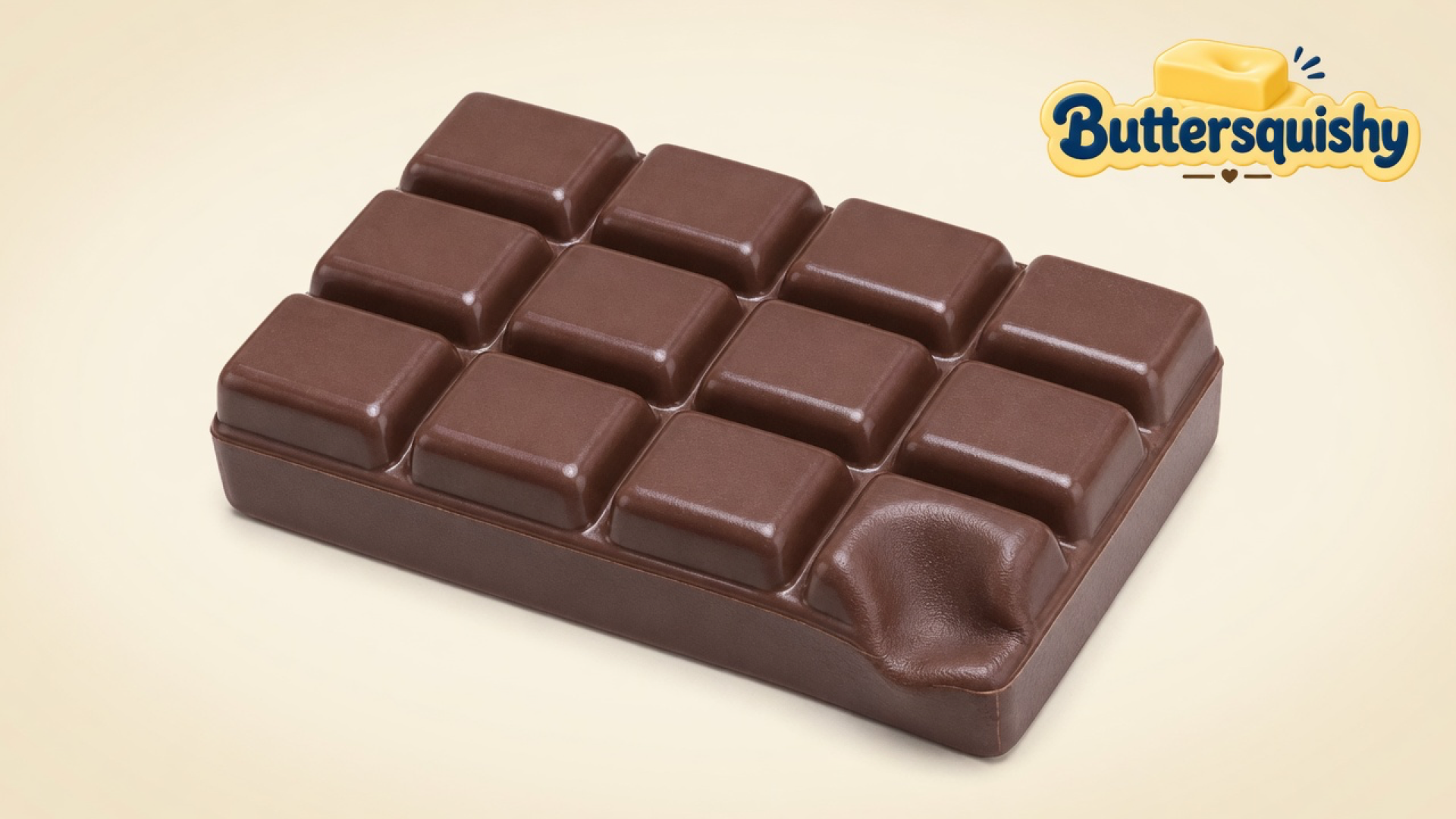 Milk-chocolate 12-square Chocolate Butter Stick with one dented cell on a light-yellow cream studio, Buttersquishy logo at the upper right