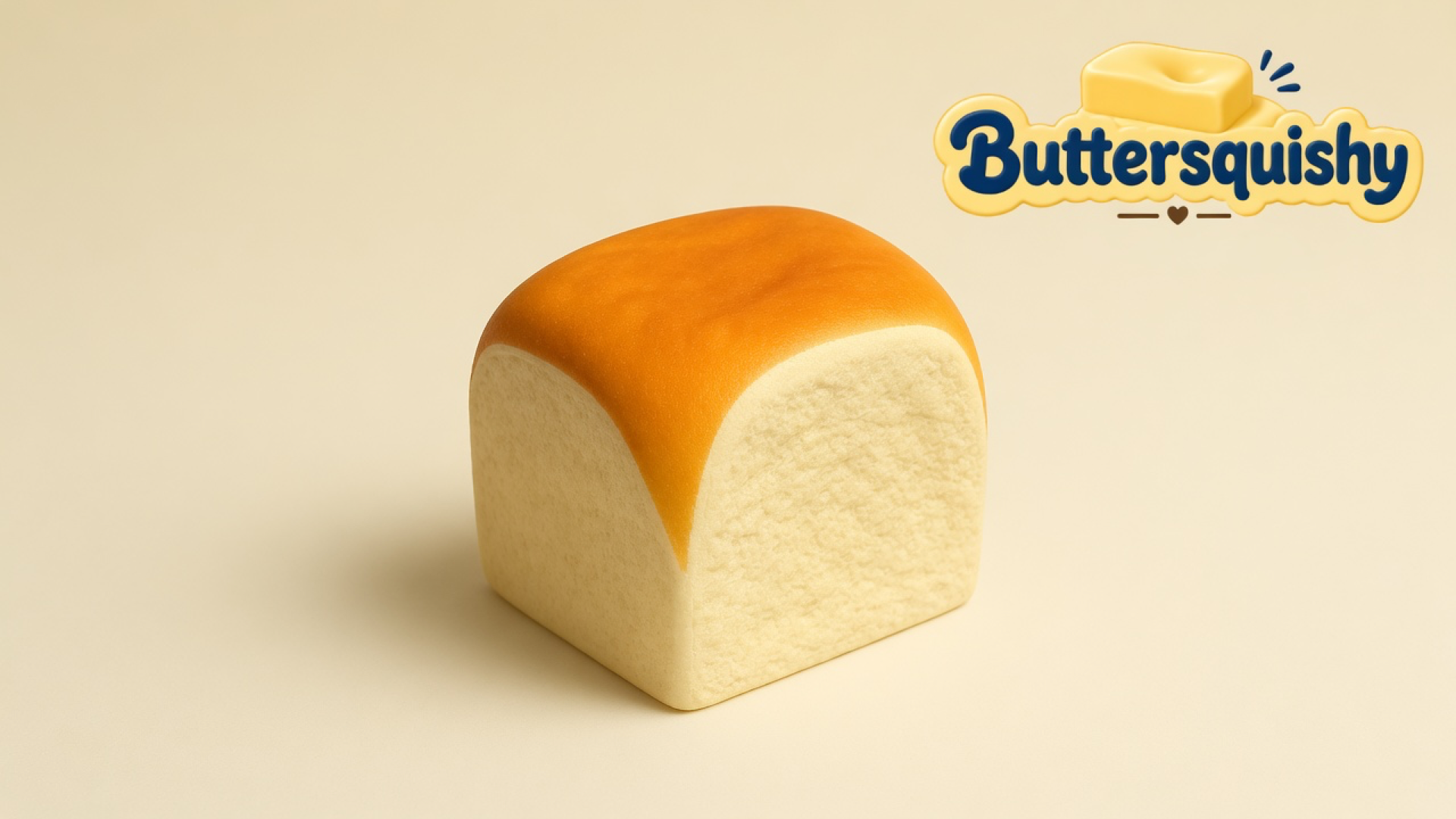Golden-crust Bread Toast Loaf milk-bread bun on a light-yellow cream studio surface, Buttersquishy logo at upper right