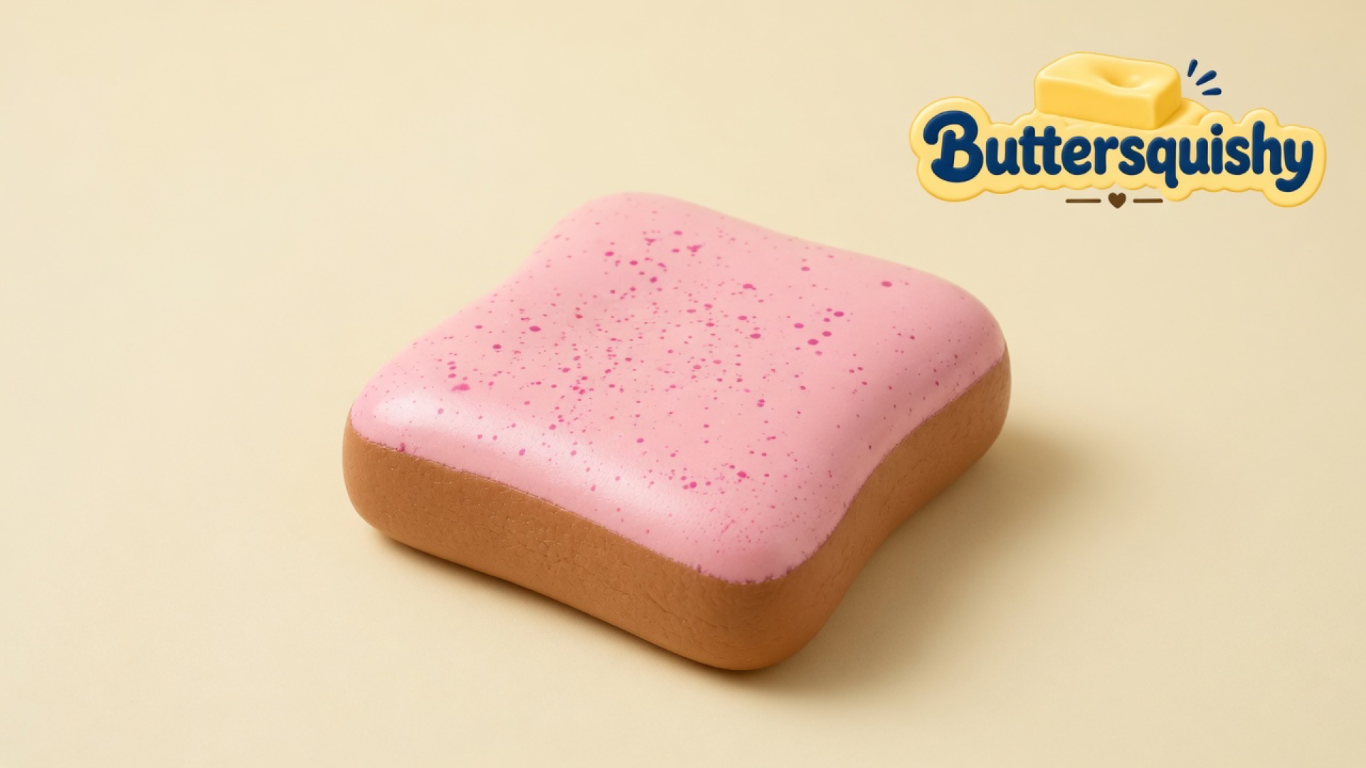 Square pink-speckled Bread Toast Loaf with a toasted-brown crust on a light-yellow cream studio, Buttersquishy logo at upper right
