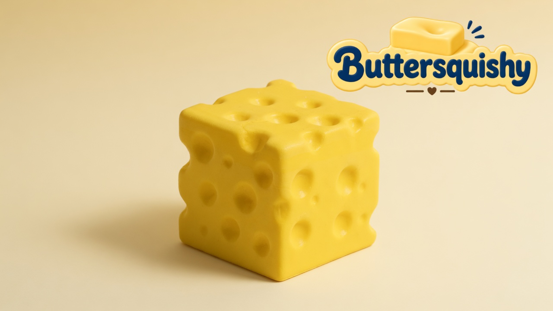 One yellow Cheese Cube Loaf with mixed-size Swiss holes on a light-yellow cream studio, Buttersquishy logo at upper right