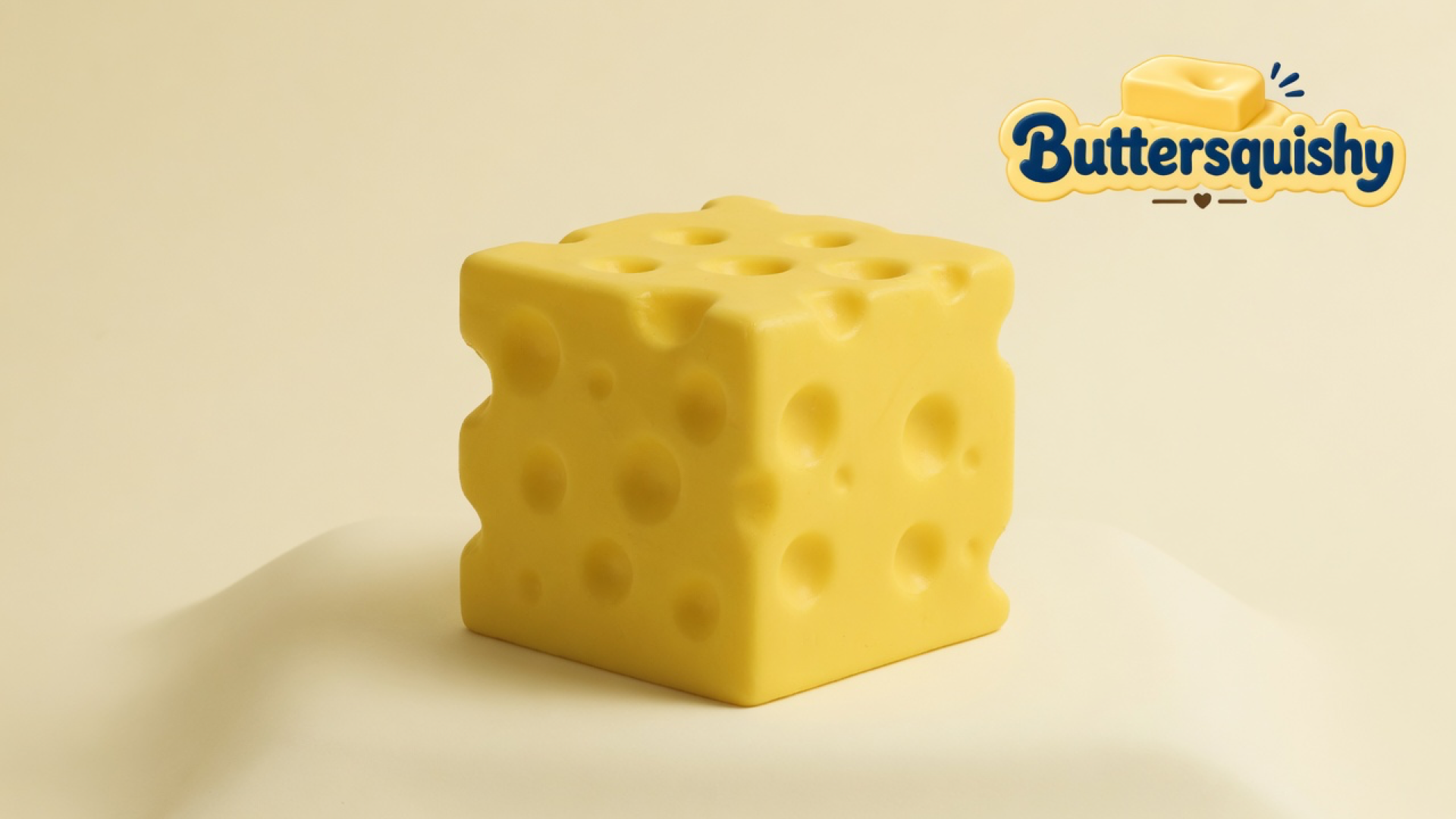 One cheddar-yellow Swiss-hole Cheese Cube Loaf on a light-yellow cream studio surface, Buttersquishy logo in the upper right