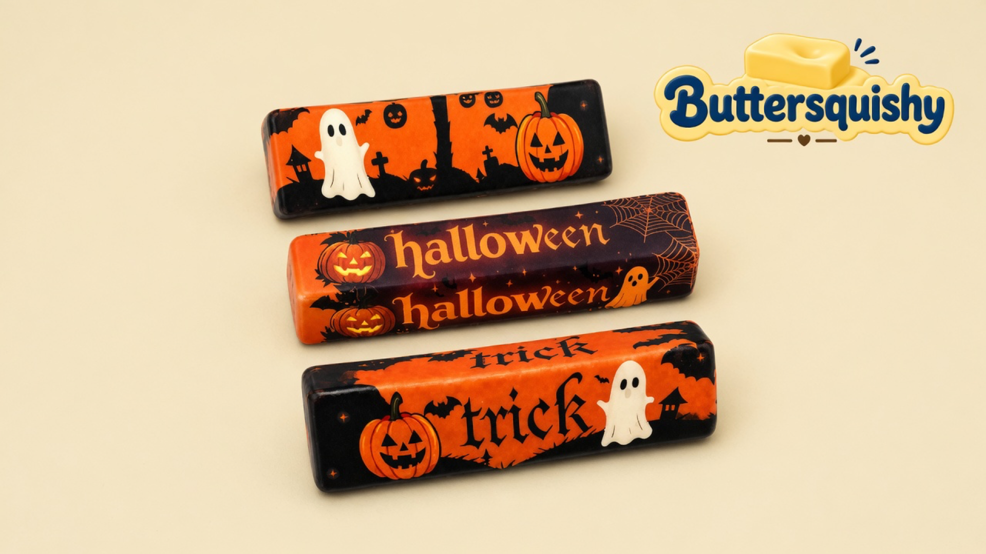 Three Halloween Ghost Butter sticks with ghost, pumpkin, halloween, and trick prints on a cream studio surface, Buttersquishy logo in the upper right
