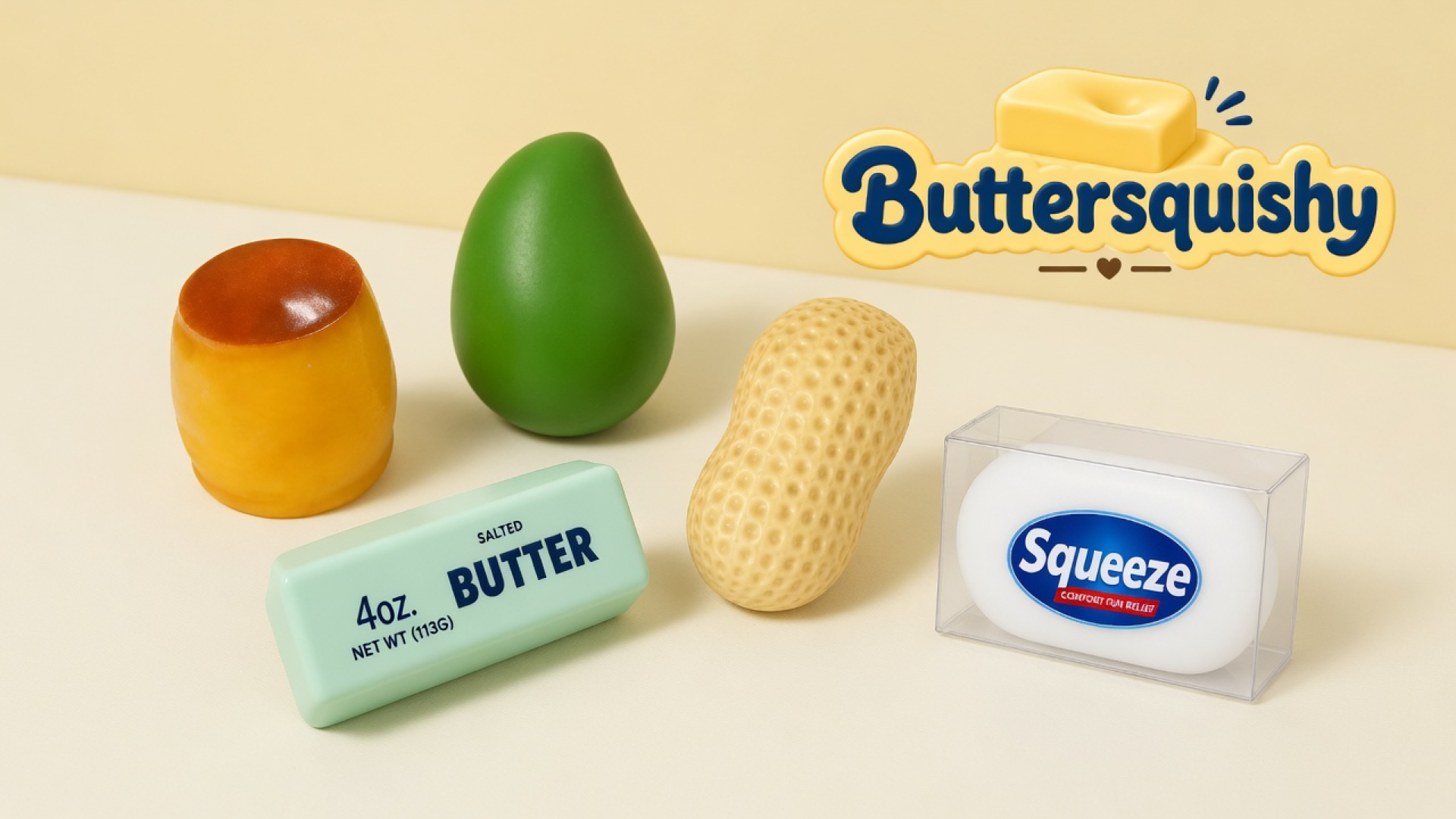 Five mixed food-look squeeze toys — caramel pudding cup, green fruit, dimpled peanut, mint salted-butter stick, and boxed white oval — on a light-yellow cream studio surface, Buttersquishy logo in the upper right