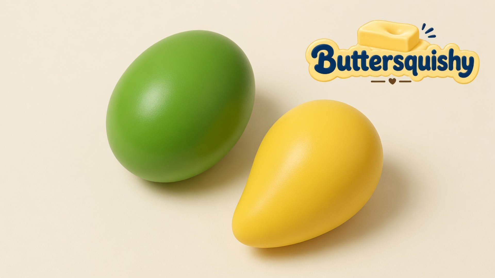 A leaf-green oval squishy and a yellow teardrop squishy on a light-yellow cream studio surface, Buttersquishy logo in the upper right