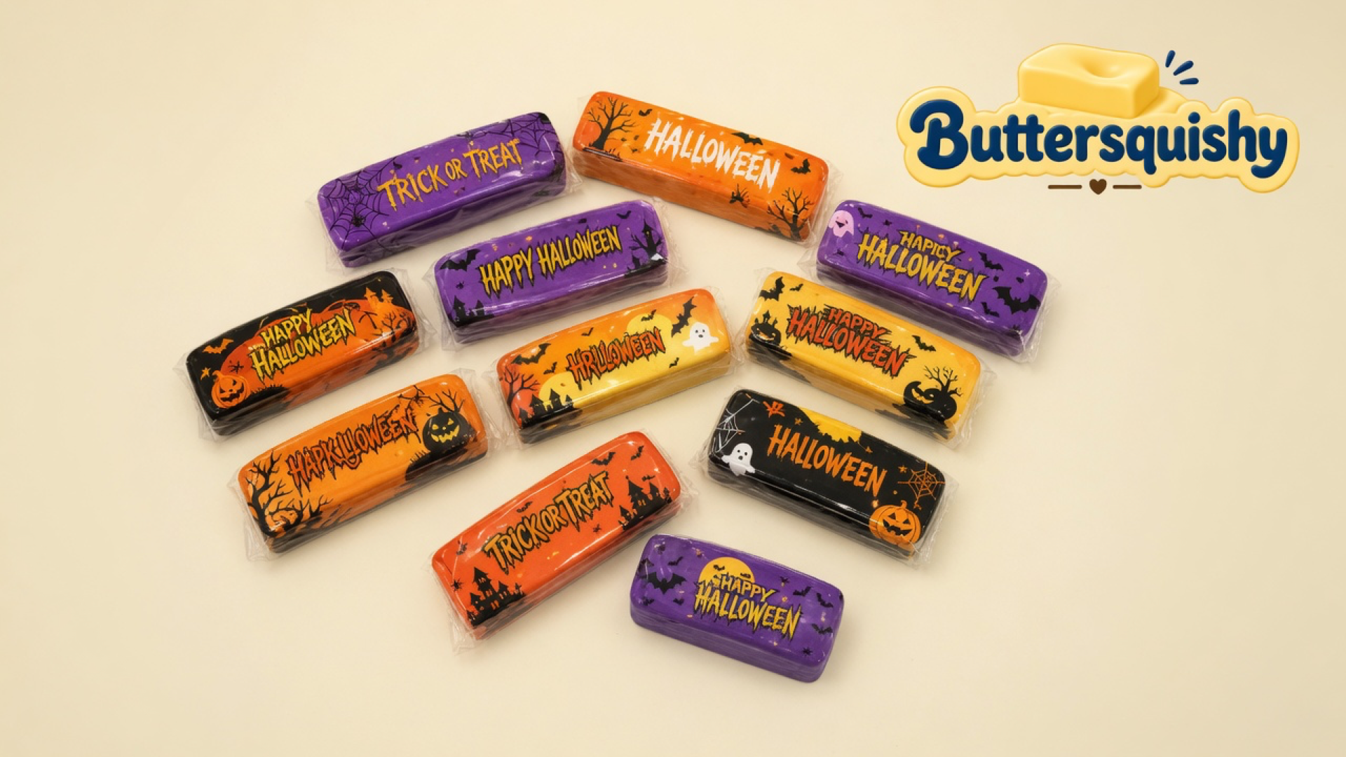 Twelve individually wrapped Halloween Ghost Butter sticks on a cream studio surface, Buttersquishy logo in the upper right