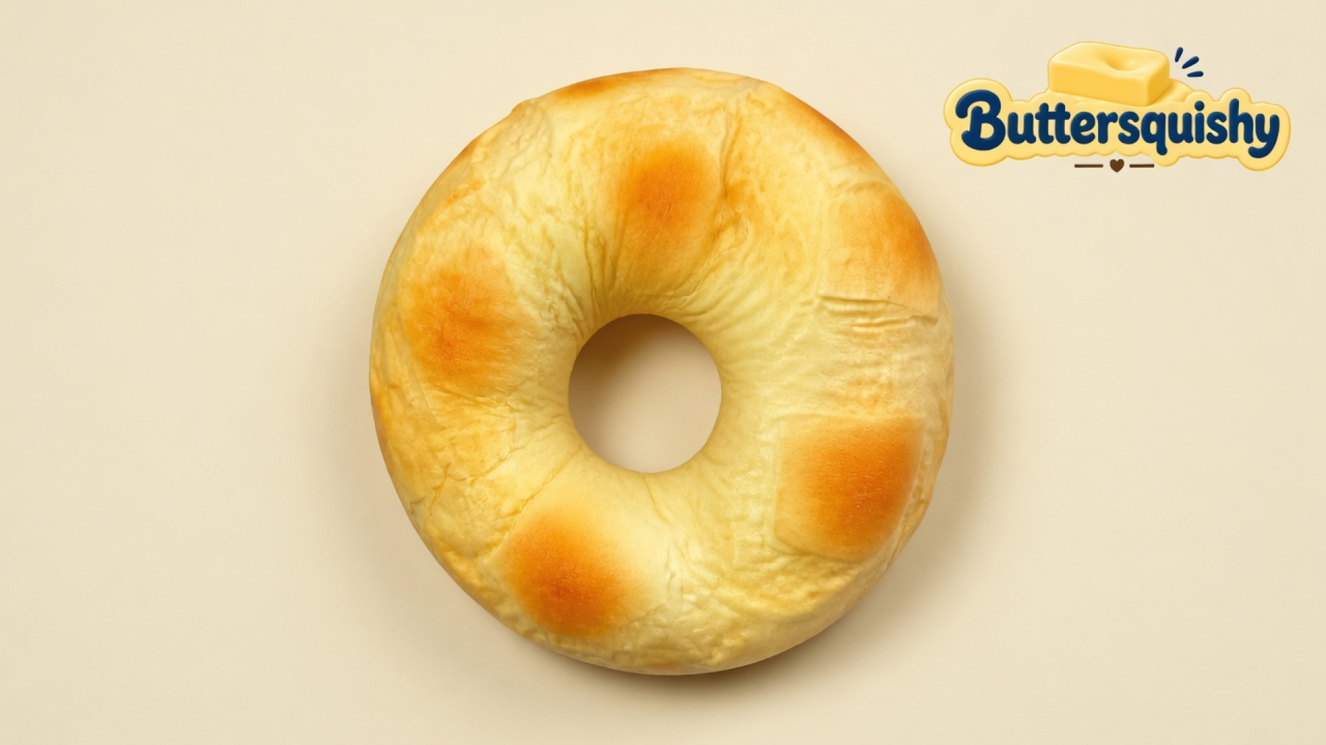 Golden bakery-ring Bread Toast Loaf on a light-yellow cream studio, Buttersquishy logo at upper right