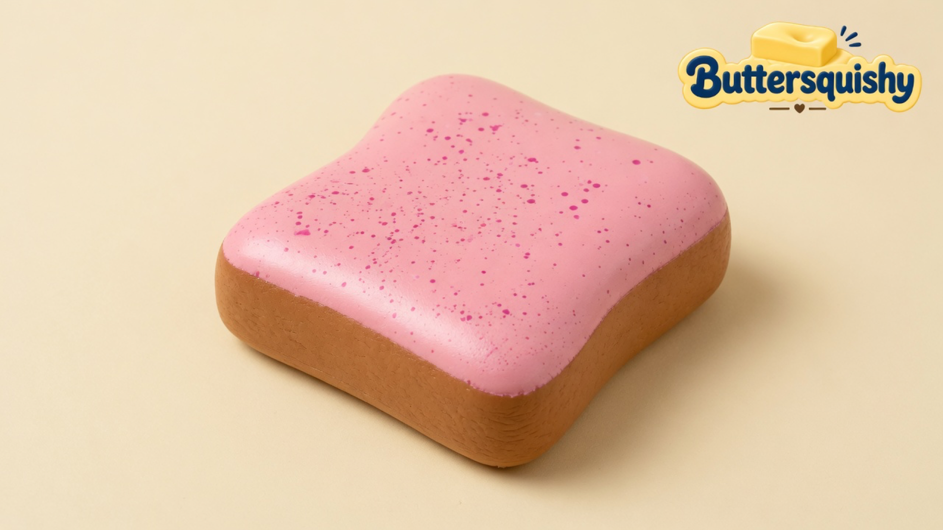 Rounded-square Bread Toast Loaf with a glossy pink speckled top and golden-brown crust on a light-yellow cream studio, Buttersquishy logo at upper right