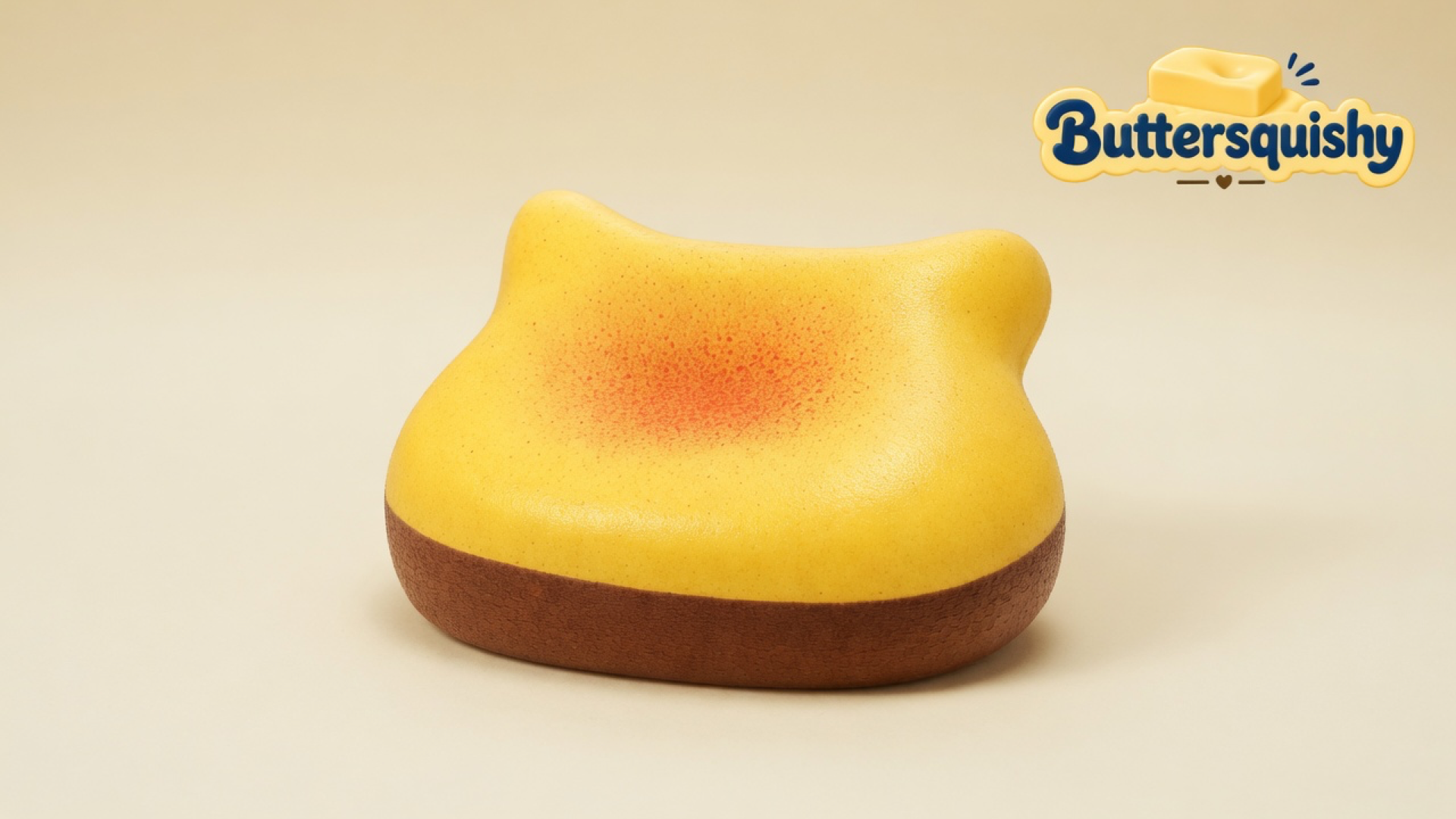 One yellow cat-eared Bread Toast Loaf with an orange-red blush and brown crust ring on a light-yellow cream studio, Buttersquishy logo at upper right