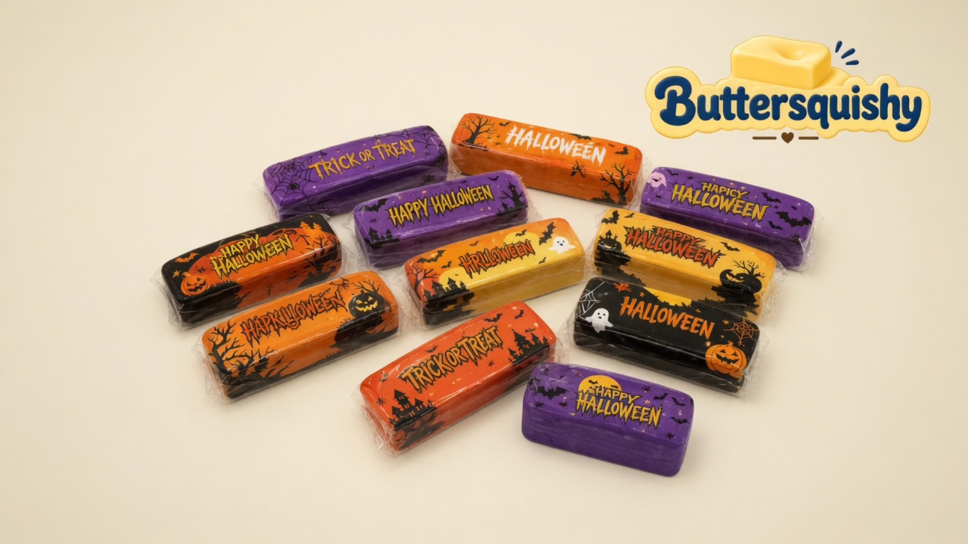 Twelve individually wrapped Halloween Ghost Butter sticks on a cream studio surface with the Buttersquishy logo in the upper right