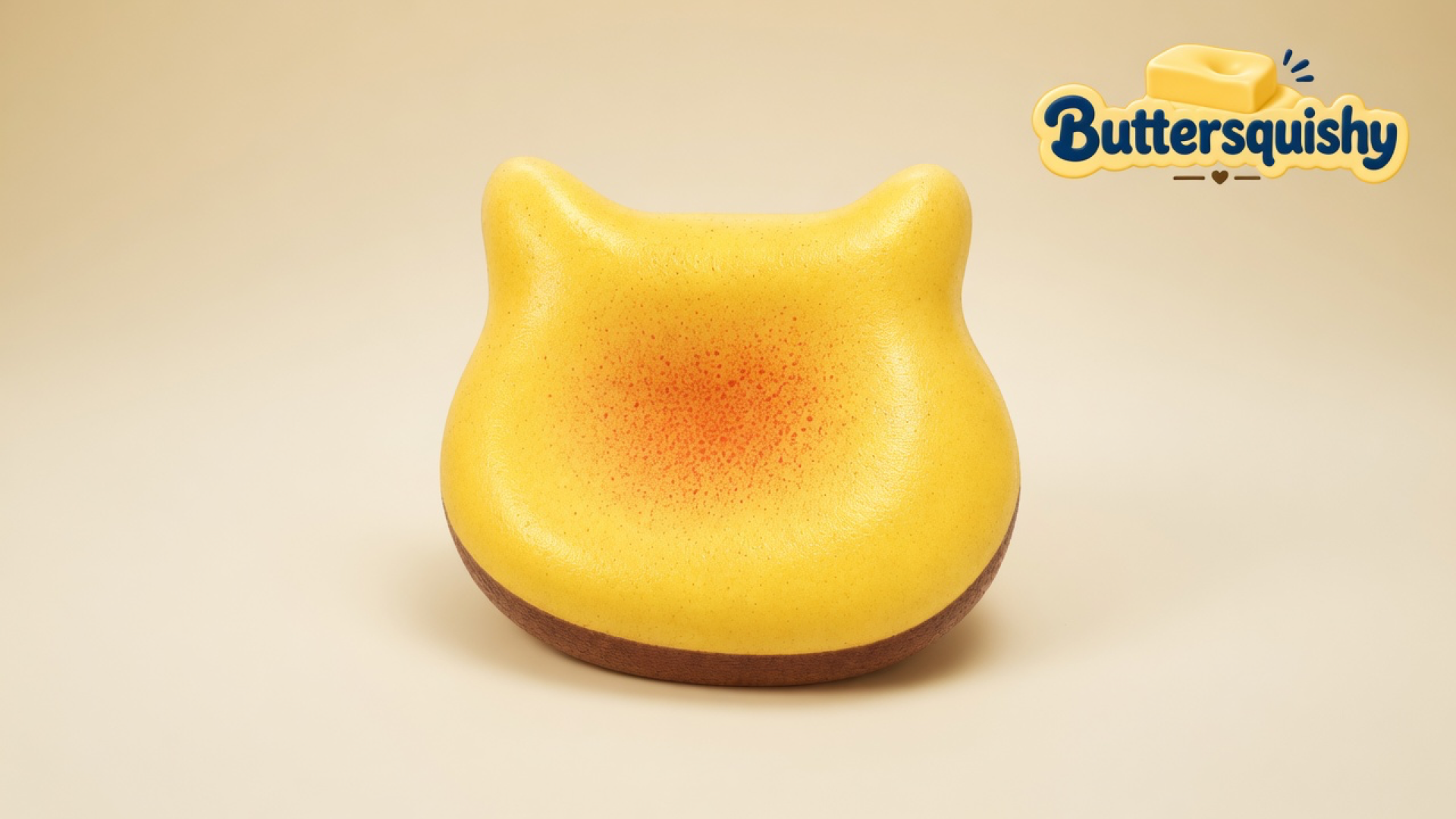 Yellow cat-ear bun loaf with a toasted orange-red center blotch and brown crust band on a light-yellow cream studio surface, Buttersquishy logo in the upper right