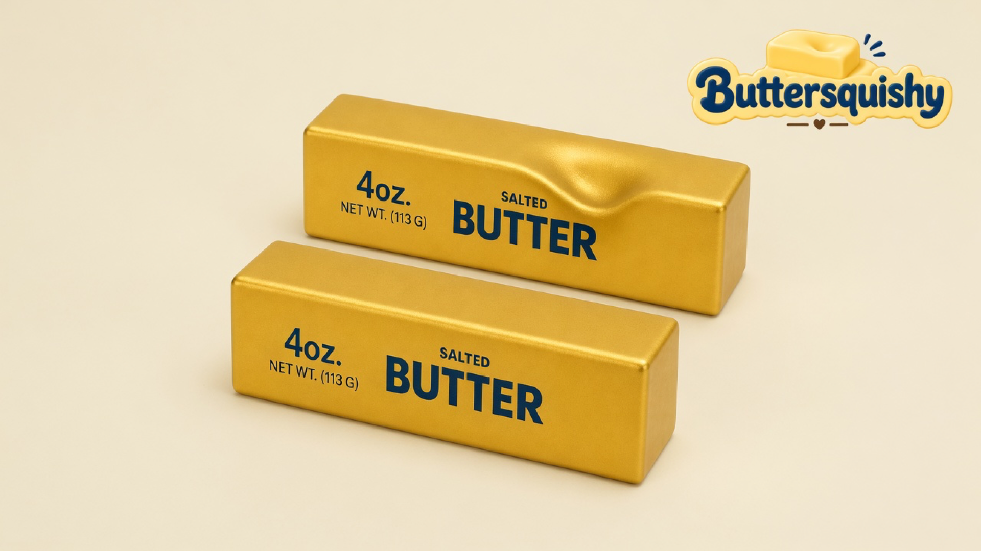Two gold-foil Golden Butter Stick loaves printed 4oz. NET WT. (113 G) SALTED BUTTER on a light-yellow cream studio surface, one with a thumb dent, Buttersquishy logo in the upper right