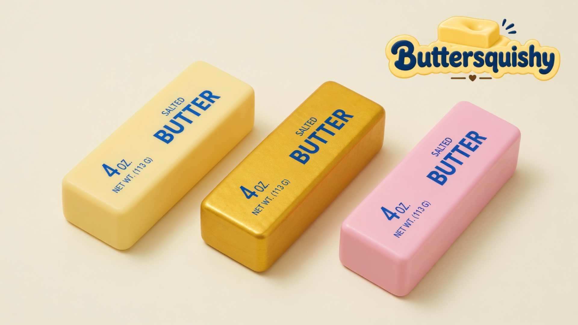 Three cream, gold, and pink Sunset Trio Butter sticks with navy SALTED BUTTER print on a light-yellow cream studio surface, Buttersquishy logo in the upper right