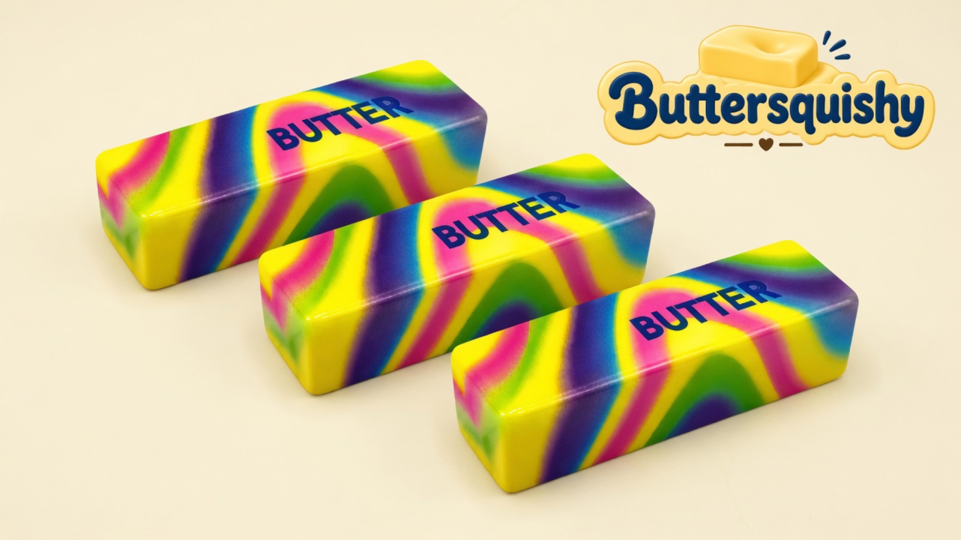 Three neon yellow-pink-green-violet swirl butter sticks printed BUTTER on a light-yellow cream studio surface, Buttersquishy logo in the upper right