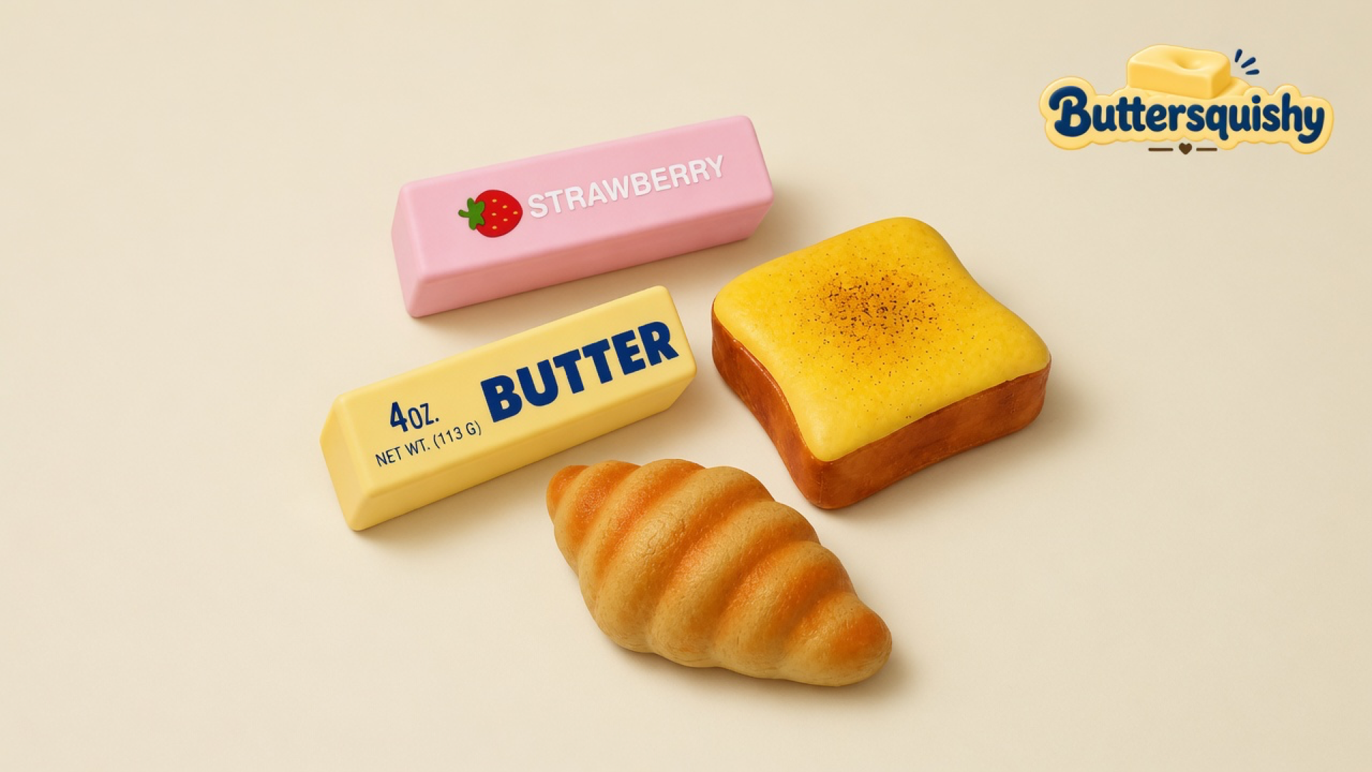 Pink STRAWBERRY stick, yellow BUTTER stick, square toast slice, and croissant on a cream studio surface, Buttersquishy logo in the upper right