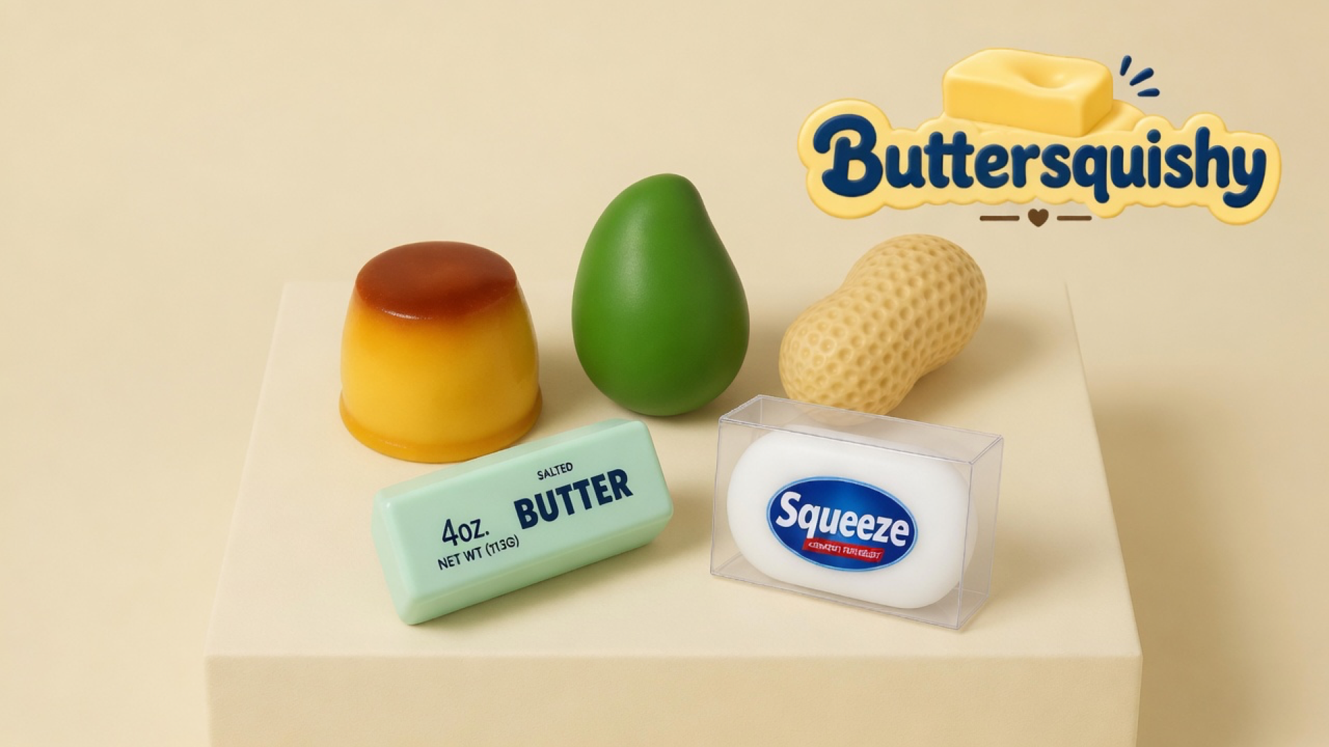Five food-look squeeze toys — caramel-top custard cup, green mango, pitted peanut, mint SALTED BUTTER stick, and boxed white Squeeze bar — on a cream studio block, Buttersquishy logo in the upper right