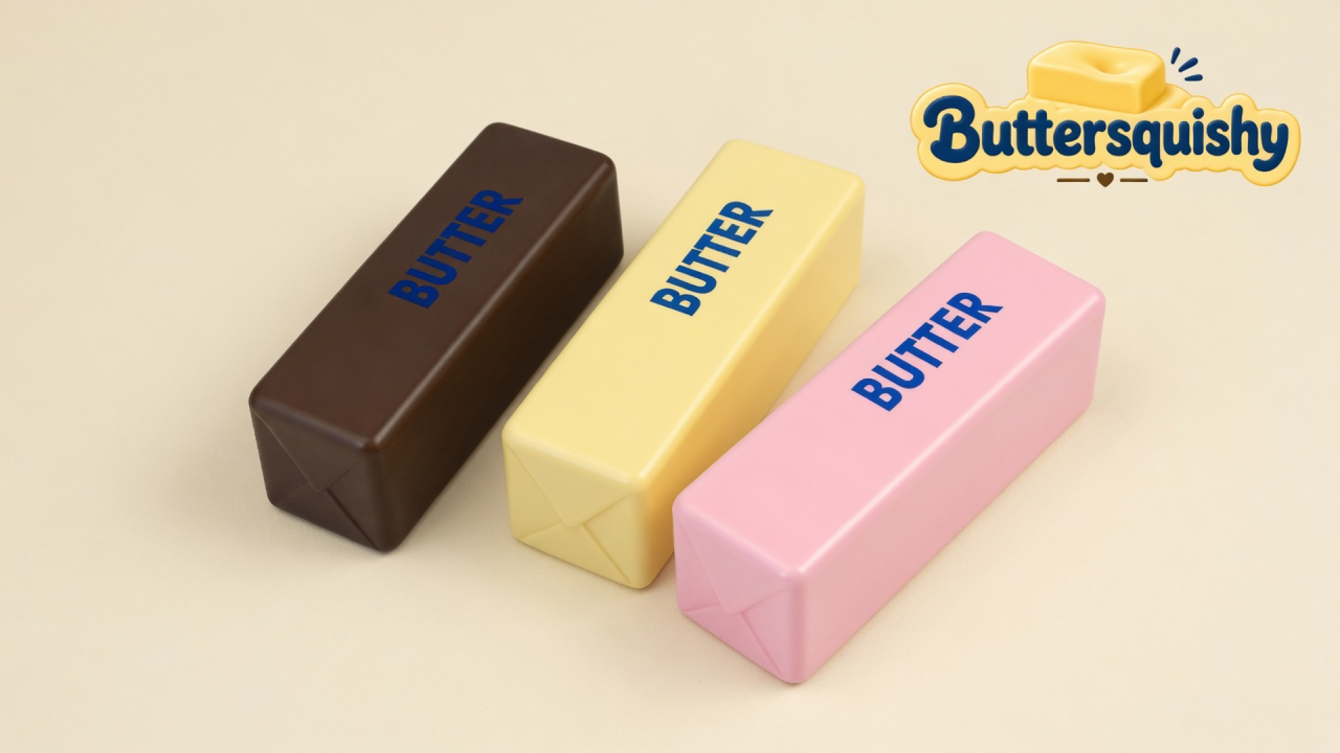 Three Chocolate Berry Butter sticks in chocolate brown, pale yellow, and berry pink with navy BUTTER prints on a cream studio surface, Buttersquishy logo in the upper right
