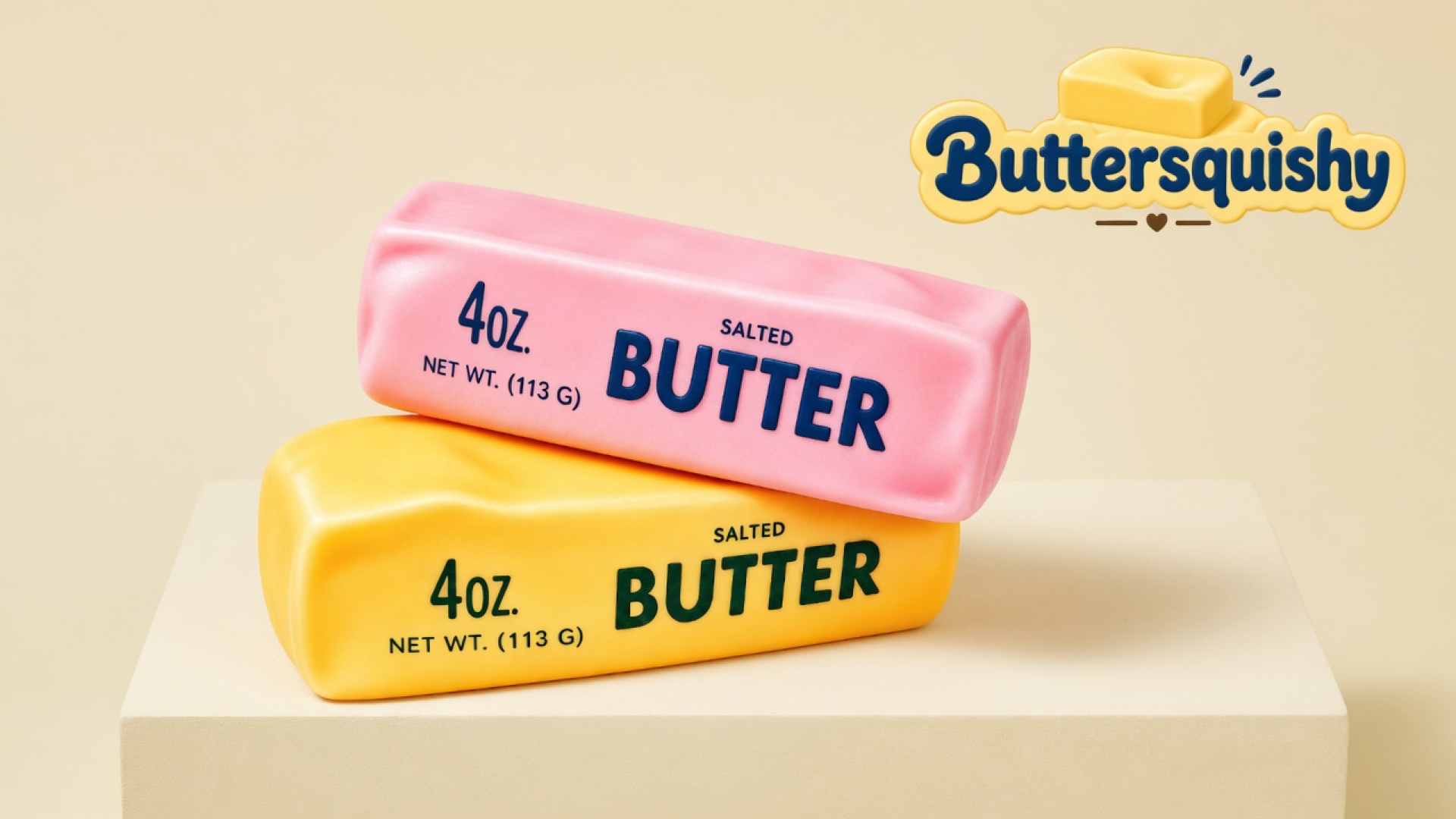 Candy-pink and yellow-orange SALTED BUTTER sticks stacked on a light-yellow cream studio block, Buttersquishy logo in the upper right