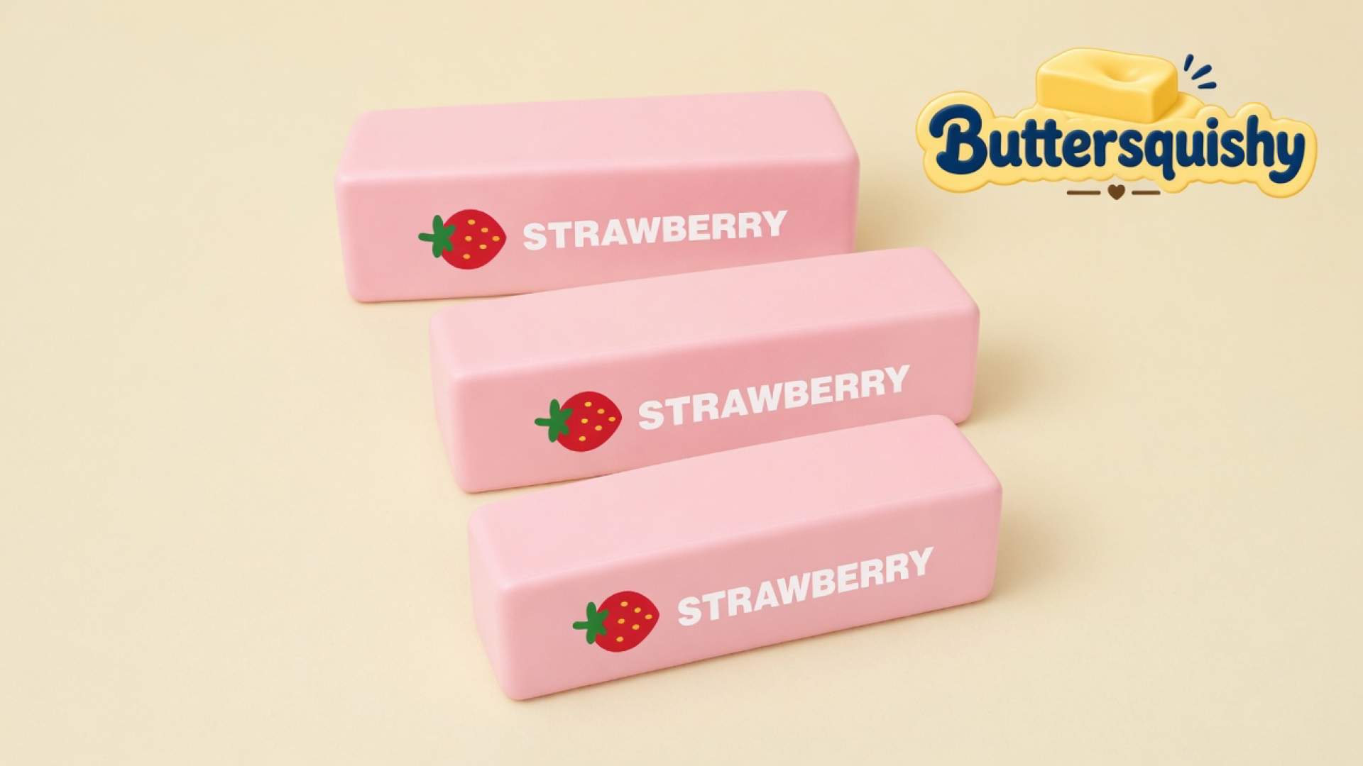 Three matching pink rectangular strawberry butter-stick toys with berry icons and STRAWBERRY type on a light-yellow cream studio surface, Buttersquishy logo in the upper right