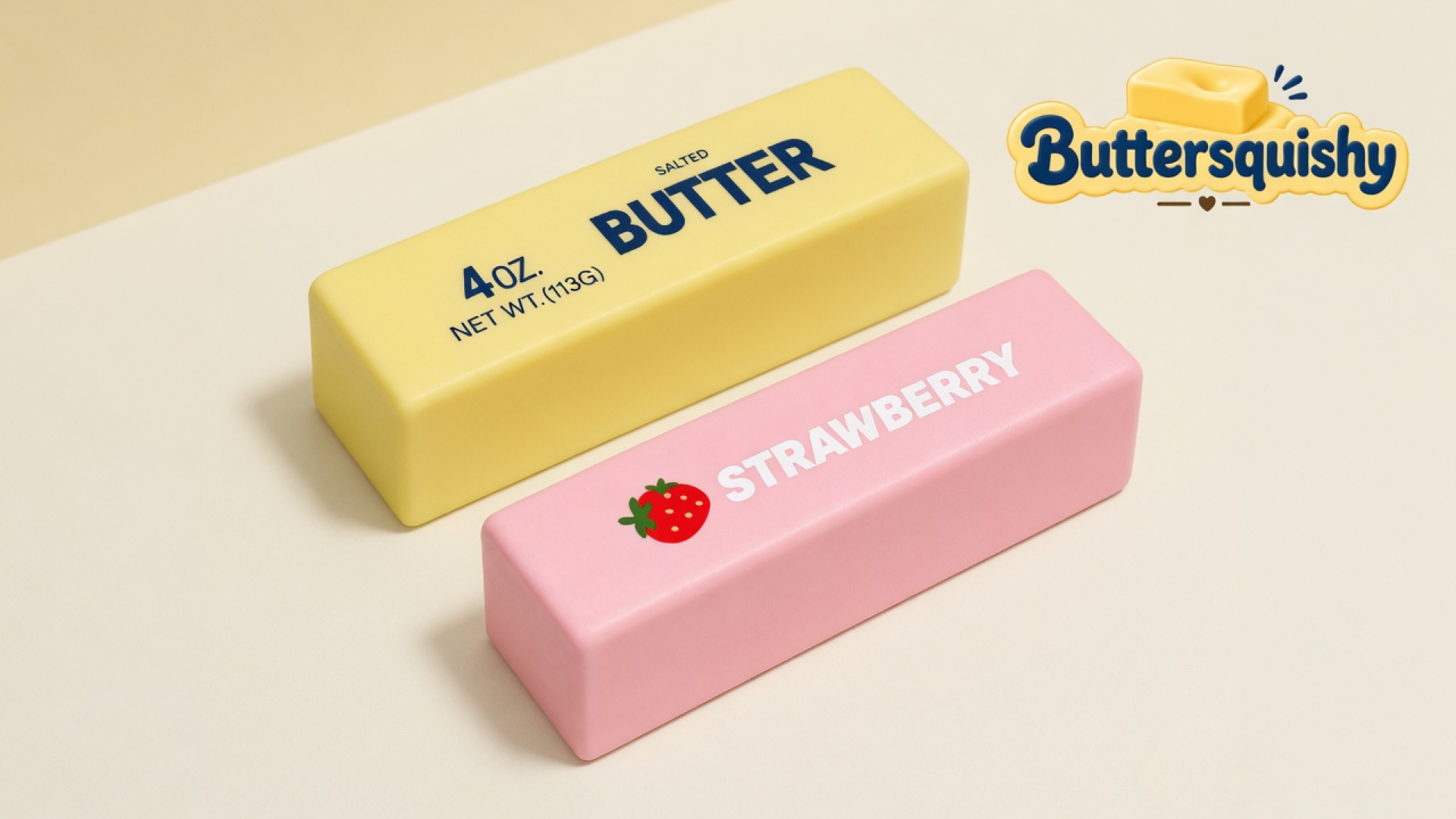 Pale yellow SALTED BUTTER loaf and pink STRAWBERRY loaf on a light-yellow cream studio background, Buttersquishy logo in the upper right