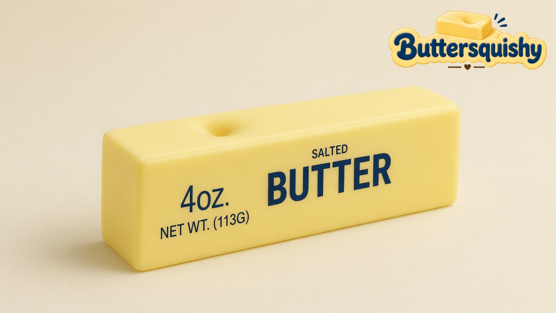 One pale-yellow Classic Gift Butter stick printed 4OZ. SALTED BUTTER with a thumb dent, on a light-yellow cream studio surface, Buttersquishy logo in the upper right
