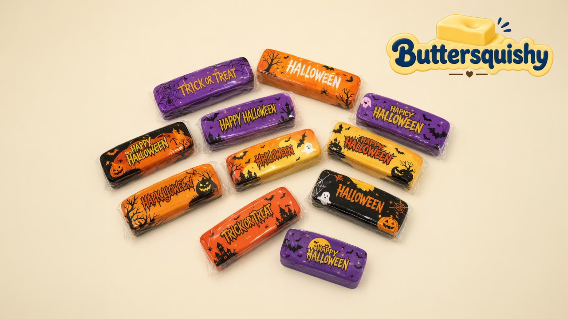 Twelve individually wrapped Halloween Ghost Butter sticks on a cream studio surface with the Buttersquishy logo in the upper right