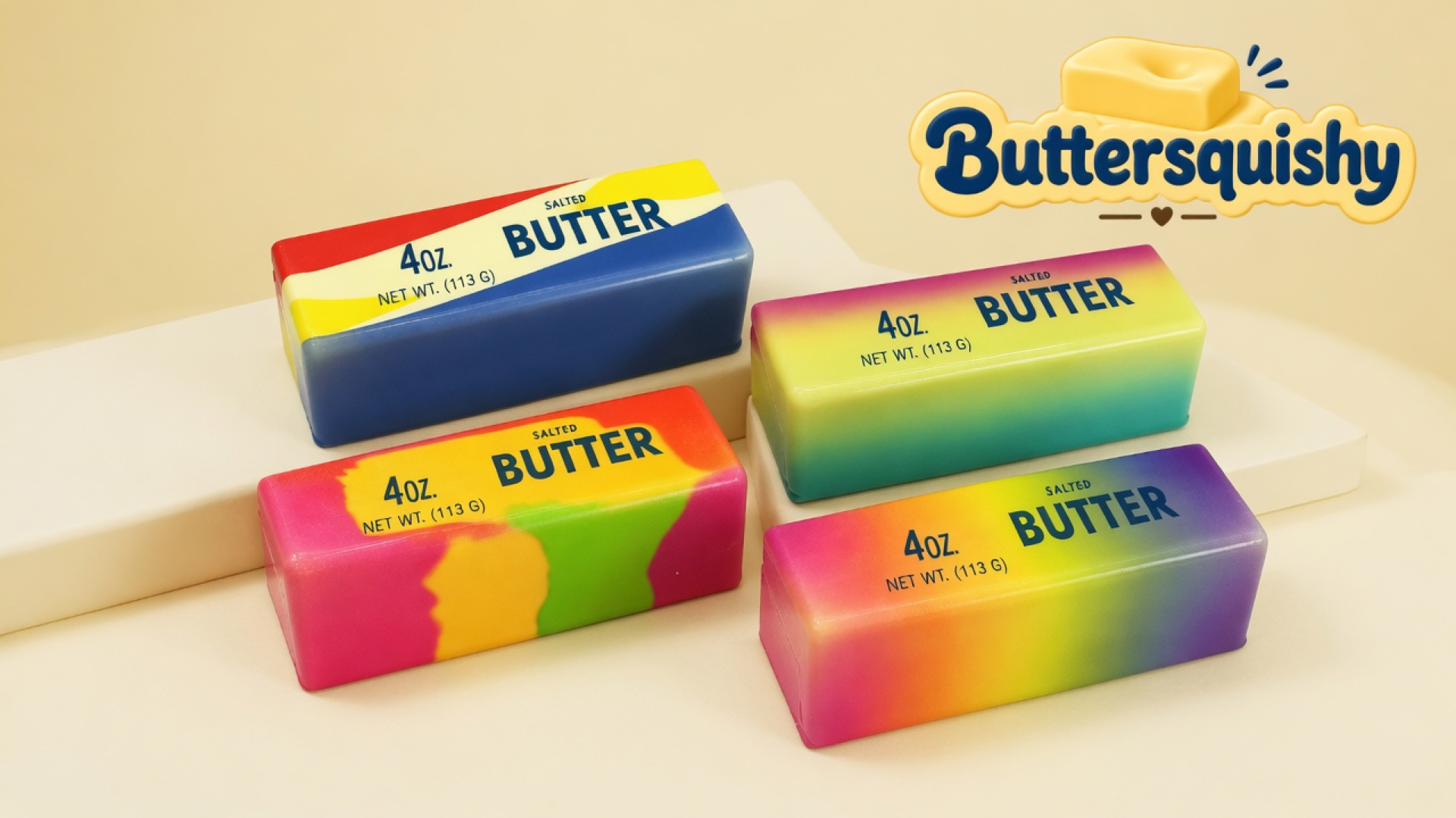 Four swirl butter-stick toys printed SALTED BUTTER 4OZ on a light-yellow cream studio surface, Buttersquishy logo in the upper right