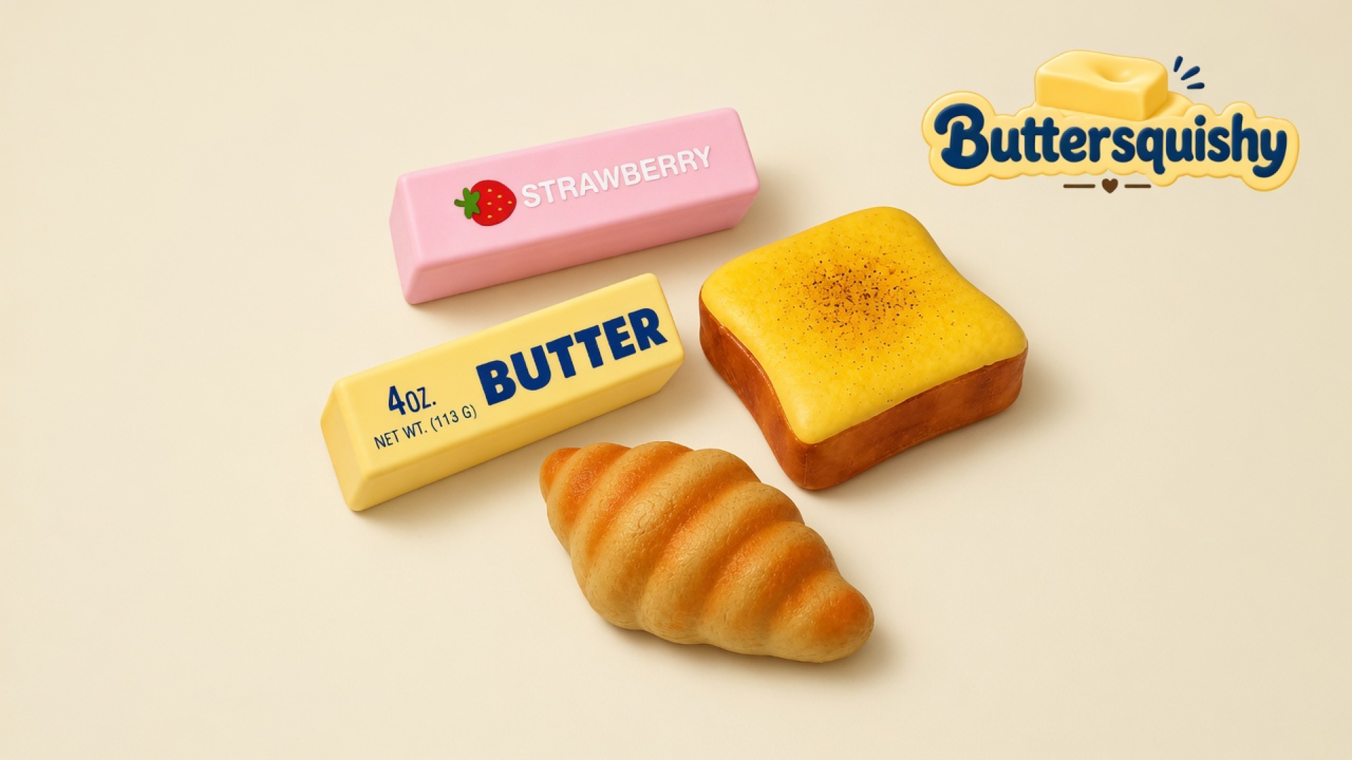 Pink STRAWBERRY stick, yellow 4oz BUTTER stick, square toast slice, and croissant on a soft light-yellow cream studio surface, Buttersquishy logo in the upper right