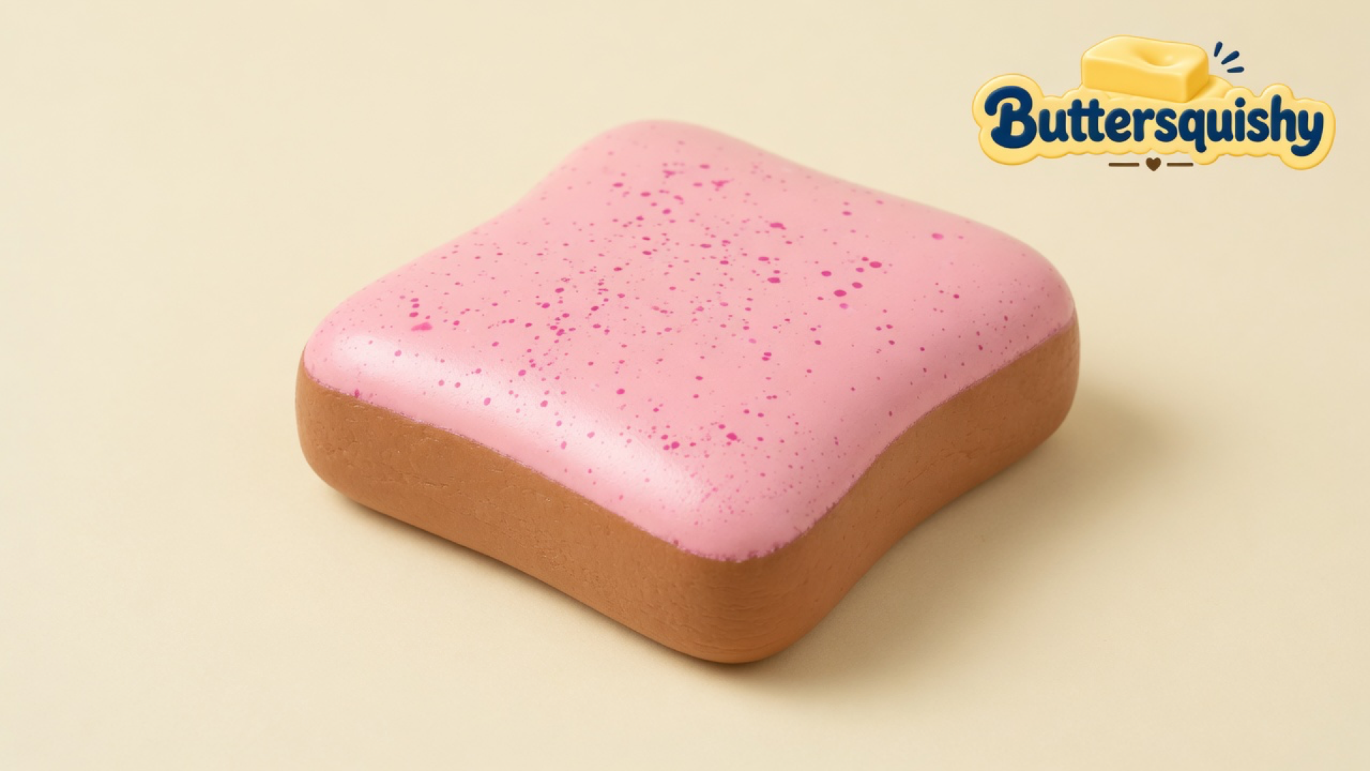 Pink-speckled toast-slice loaf with a brown crust on a light-yellow cream studio surface, Buttersquishy logo in the upper right