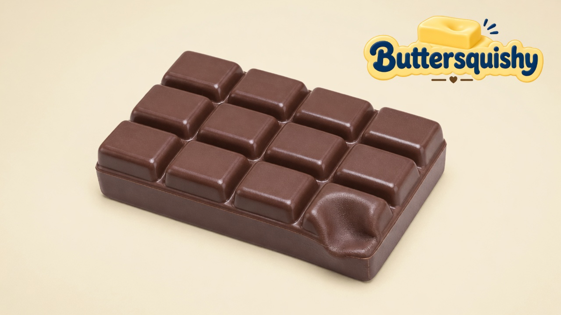 One milk-chocolate bar squishy with a twelve-square grid and one dented corner square, on a light-yellow cream studio, Buttersquishy logo in the upper right