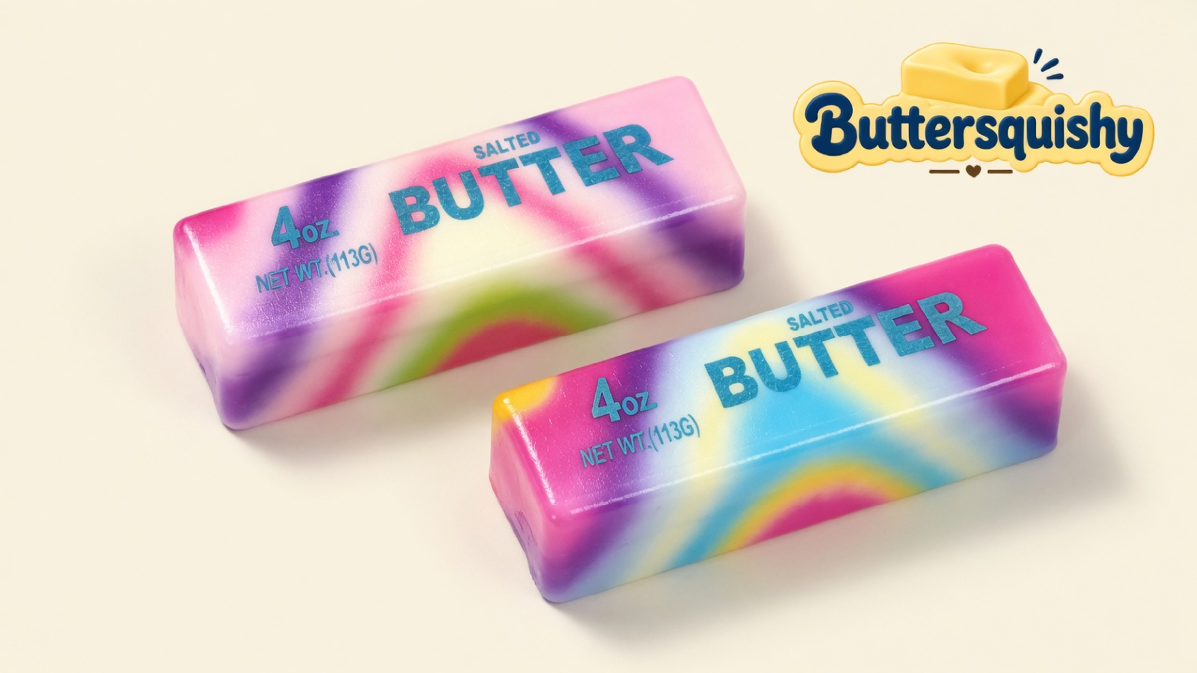 Two pink-purple-blue-yellow tie-dye butter sticks printed 4OZ NET WT.(113G) BUTTER SALTED on a light-yellow cream studio surface, Buttersquishy logo in the upper right