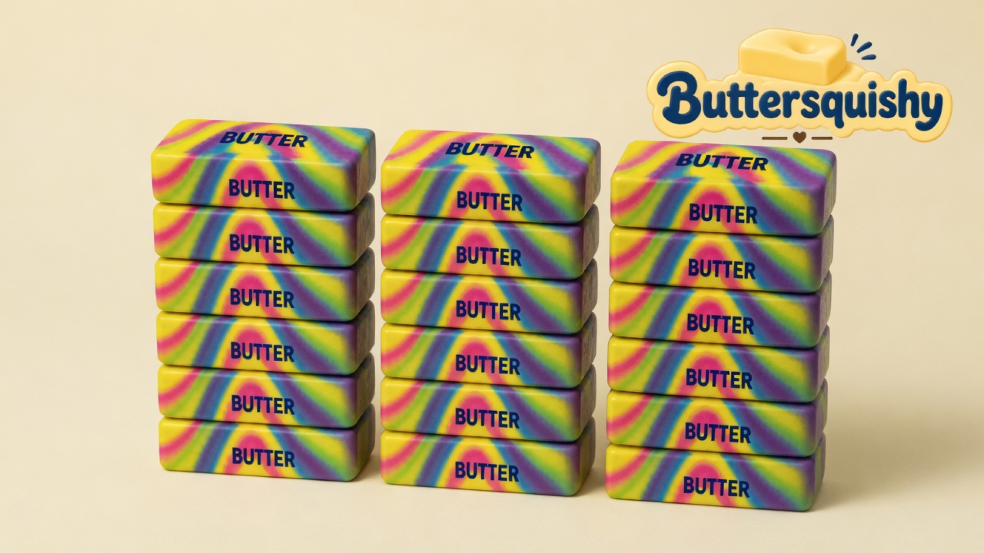 Eighteen Neon Swirl Butter sticks stacked in three columns of six, melted yellow-magenta-cyan-purple swirls with navy BUTTER print, on a light-yellow cream studio, Buttersquishy logo in the upper right