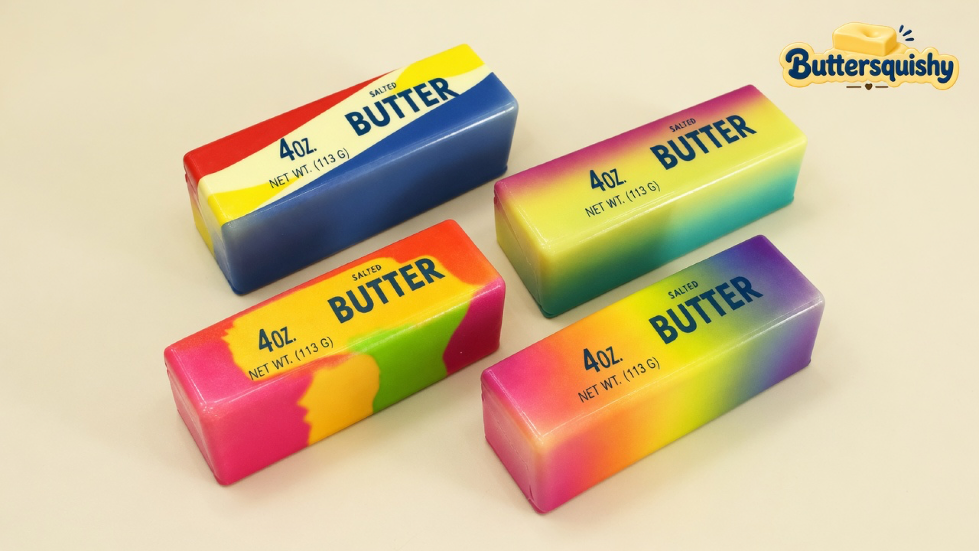 Four rectangular swirl butter sticks — red-blue grocery wrap, purple-teal wash, pink-lime splash, and pink-orange-purple gradient — each printed 4OZ SALTED BUTTER, on a light-yellow cream studio, Buttersquishy logo in the upper right