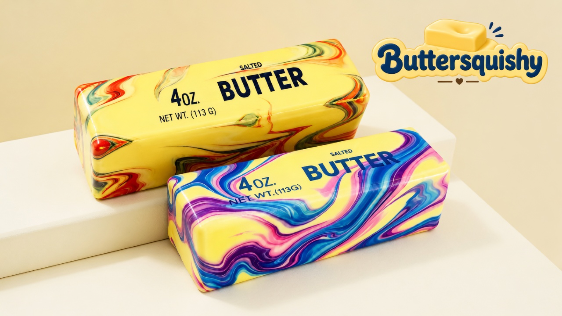 Two rectangular butter-loaf toys — one warm red-green marble with black SALTED BUTTER type, one cool blue-purple marble with blue type — on a light-yellow cream studio, Buttersquishy logo at upper right