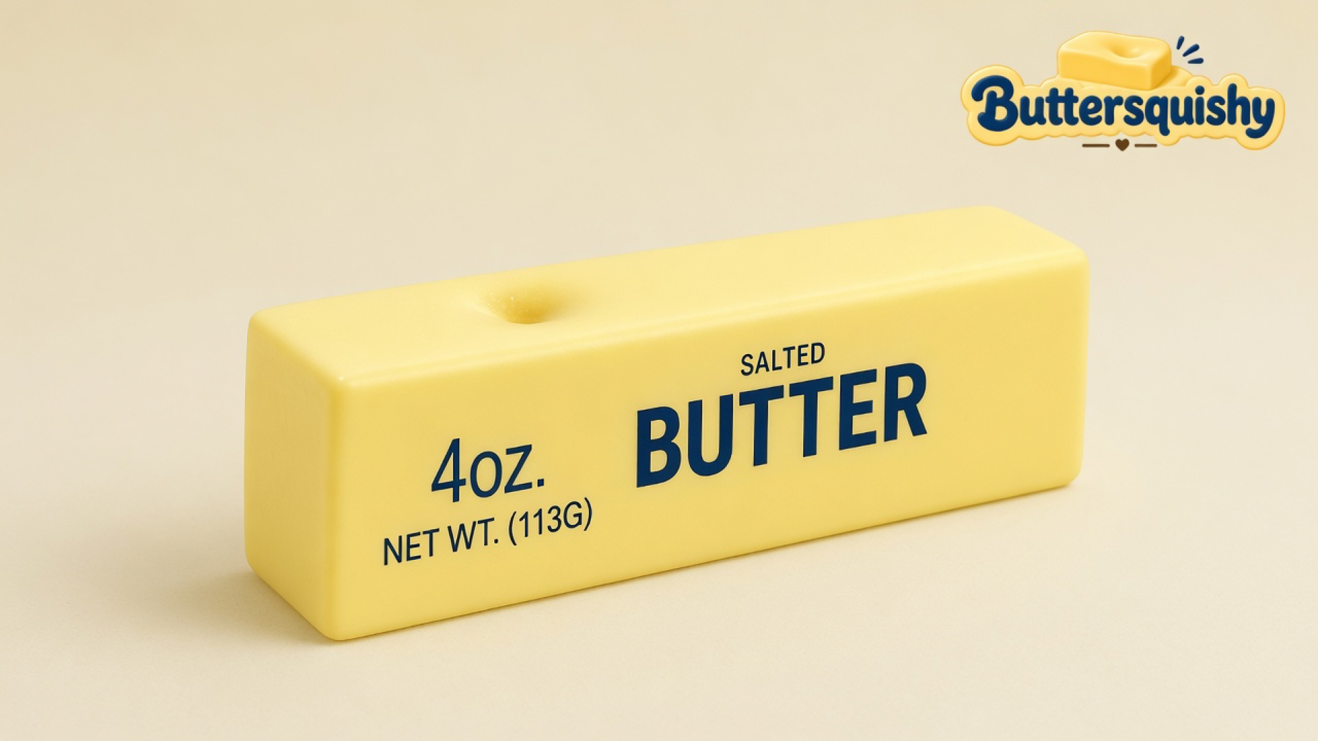 A pale yellow Classic Gift Butter stick printed 4OZ SALTED BUTTER with a thumb dent on top, on a light-yellow cream studio surface, Buttersquishy logo in the upper right