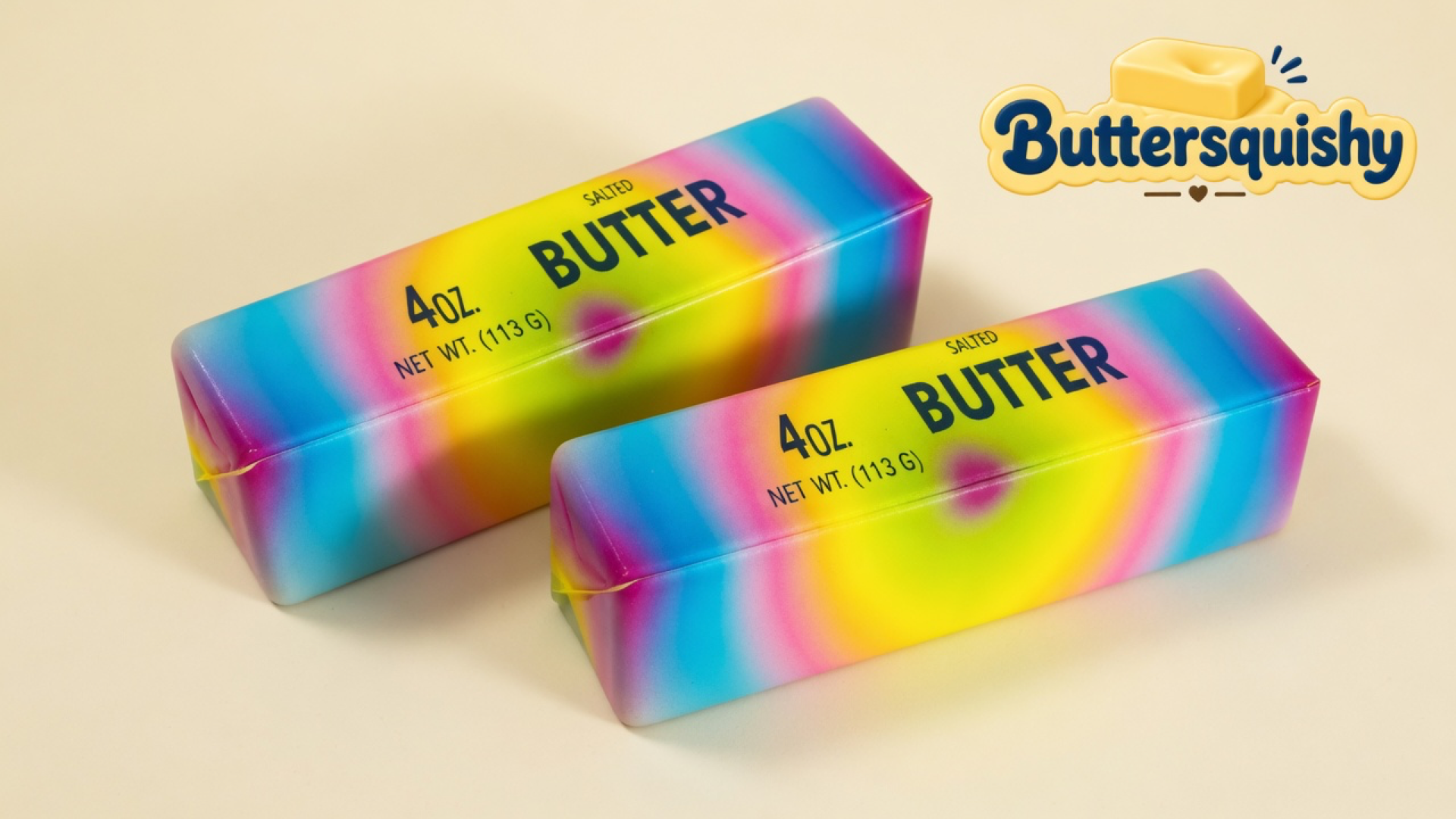 Two candy-gradient SALTED BUTTER loaves with cyan-to-magenta wash and yellow-pink bullseyes on a light-yellow cream studio, Buttersquishy logo in the upper right