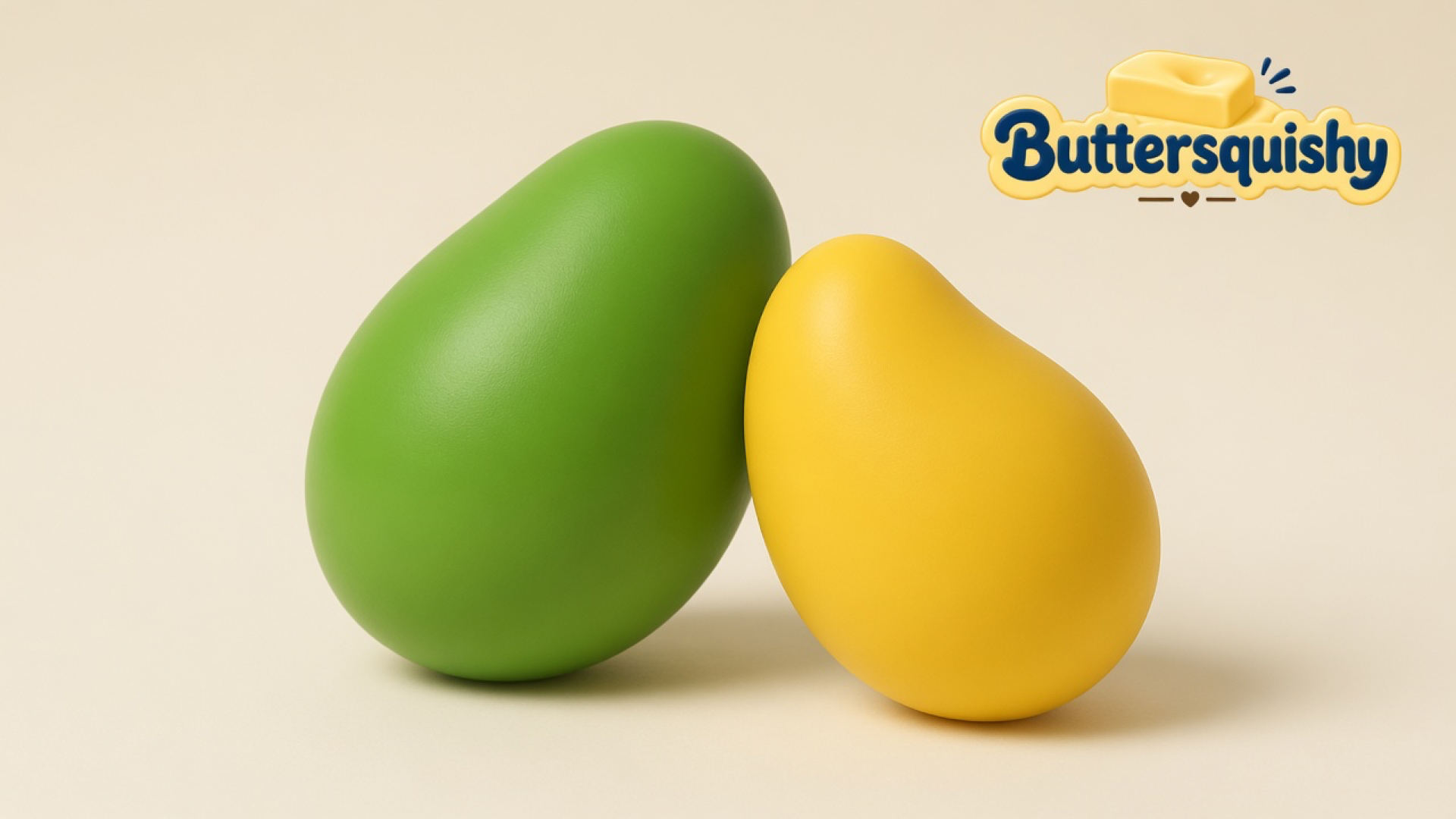 Grass-green mango oval and yellow teardrop Mixed Butter Pack toys on a light-yellow cream studio surface, with the Buttersquishy logo in the upper right