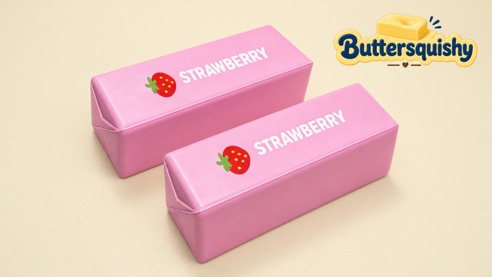 Two matching pink strawberry-print butter sticks on a light-yellow cream studio, with the Buttersquishy logo in the upper right