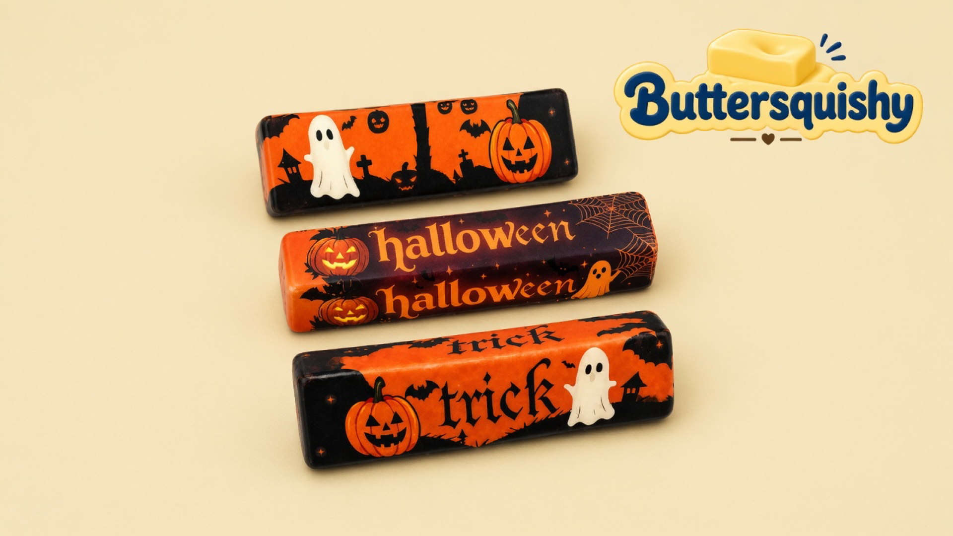 Three Halloween Ghost Butter sticks with ghost, pumpkin, halloween, and trick prints on a cream studio surface, Buttersquishy logo in the upper right