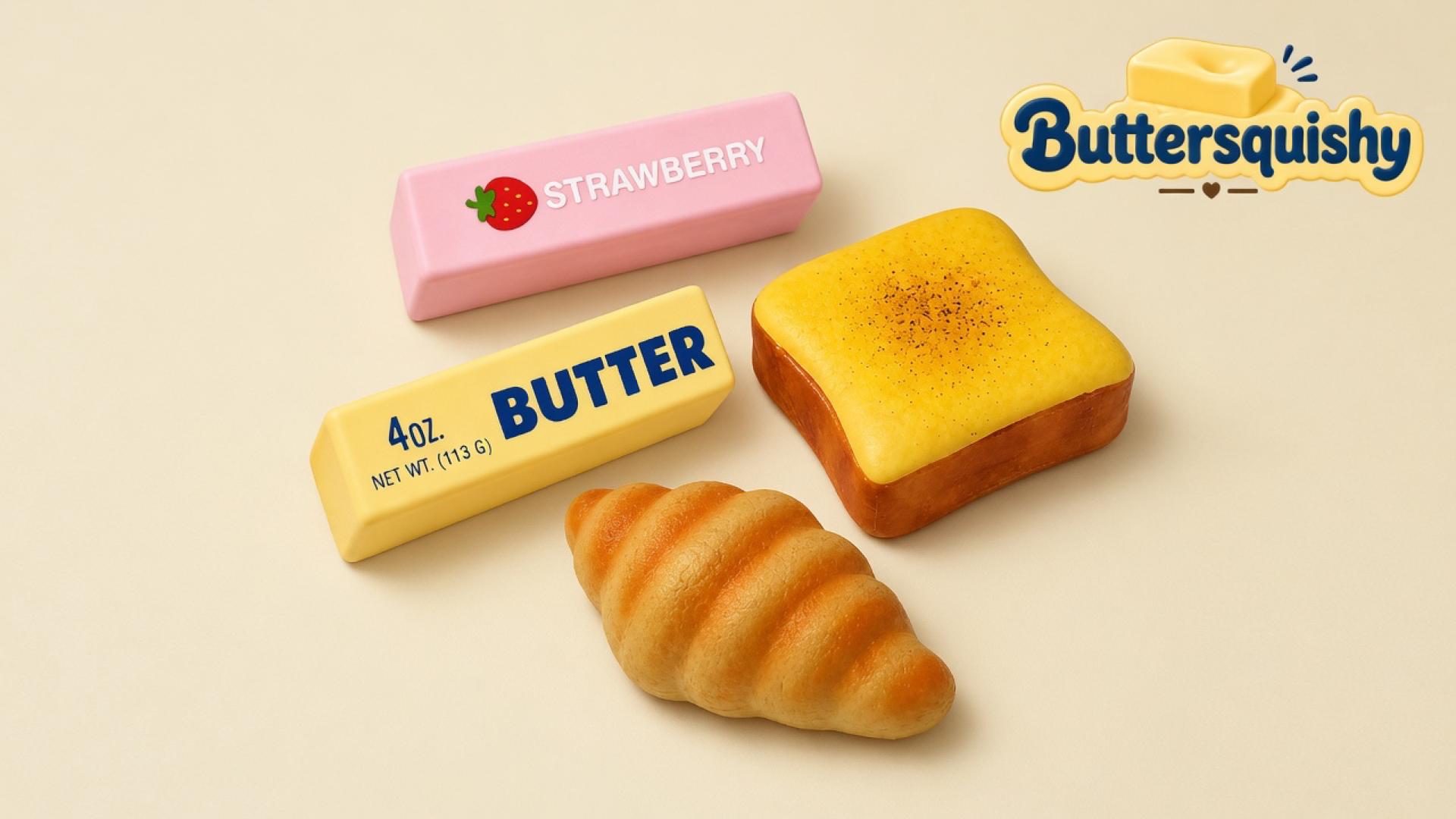 Pink strawberry stick, yellow butter-print stick, square toast loaf, and ridged croissant on a light-yellow cream studio surface, Buttersquishy logo in the upper right